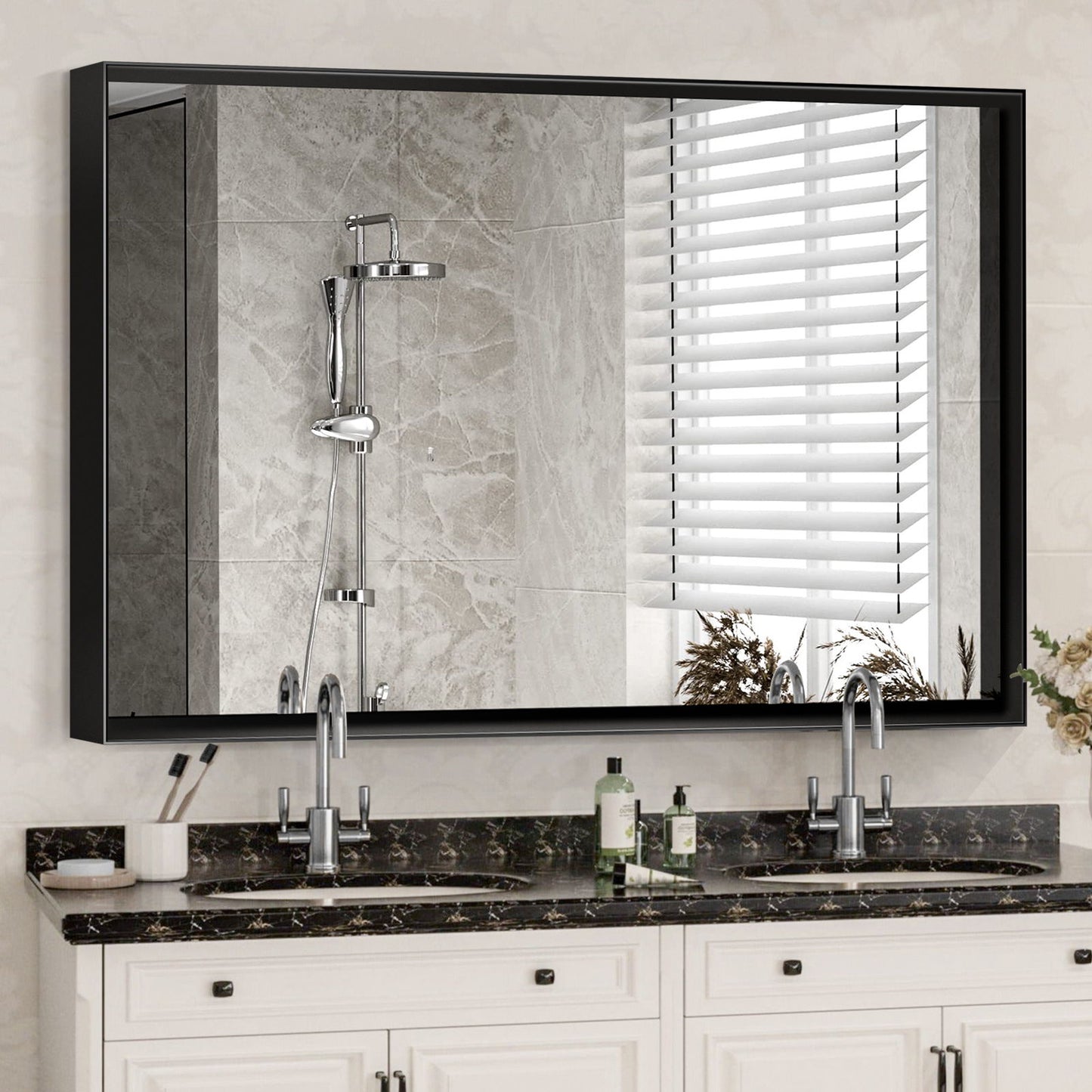 A Rectangular Bathroom Mirror with a square angle metal frame is mounted above a double sink vanity with marble countertop, soap dispenser, and toothbrush holder; it reflects a tiled shower with rainfall showerhead and window blinds.