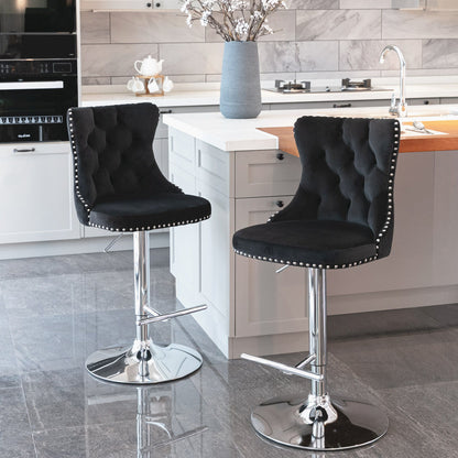 A set of two Swivel Velvet Barstools with chrome bases and tufted backs sits by a modern white kitchen island with a built-in sink and flowers; the kitchen features gray tile floors and white cabinetry.