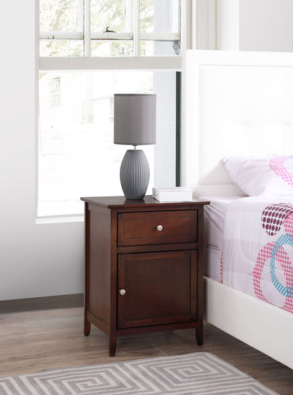 The Izzy - 1 Drawer /1 Door Nightstand stands by a white bed. It features a drawer and cabinet, topped with a gray lamp and tissue box. A window behind it bathes the scene in natural light.