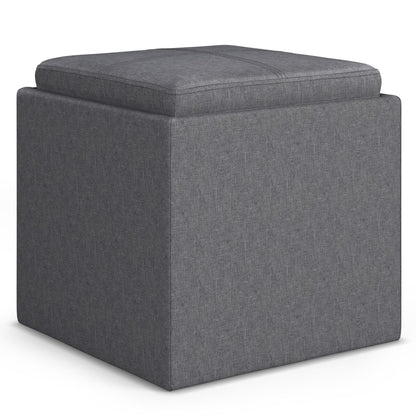 The Rockwood Upholstered Cube Storage Ottoman With Tray features a gray, cushioned top, smooth fabric upholstery with visible stitching, and a sturdy square design that is both modern and functional.