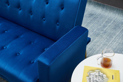 A Comfort Compact Design Sofa Bed in blue velvet sits next to a white round table with a glass cup of tea and a yellow magazine, all placed on a blue-gray rug.