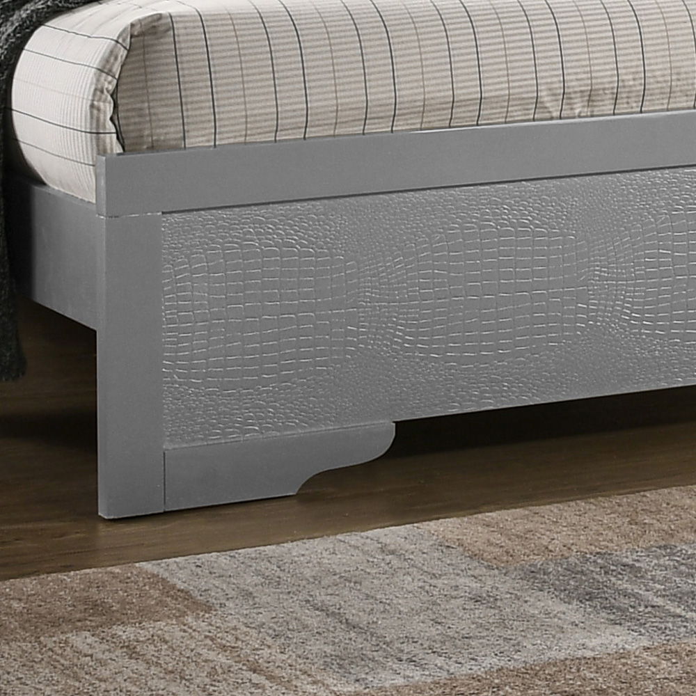 A close-up of the Chic Elegantly Designed Transitional Bed showcases its gray wooden frame with textured panels, topped with a striped mattress and accompanied by a beige and gray area rug on a wooden floor.