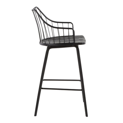 Side view of the Winston - Farmhouse Counter Stool, featuring a modern black metal frame, curved wire backrest, slender legs, rectangular footrest, and a wood-finish seat.