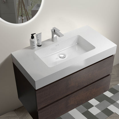 The Alice Wall Mounted Bathroom Vanity features a white one-piece rectangular sink and large dark wood storage. Shown with chrome faucet, two soap dispensers, a round illuminated mirror, and patterned floor tiles partially visible.