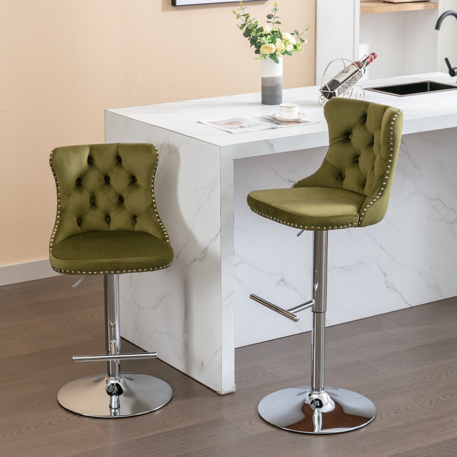 Two Swivel Velvet Barstools with adjustable seat height (25-33") and tufted backs on chrome bases stand by a white marble kitchen island, accented by flowers, wine, and a glass. The floor beneath is dark wood.