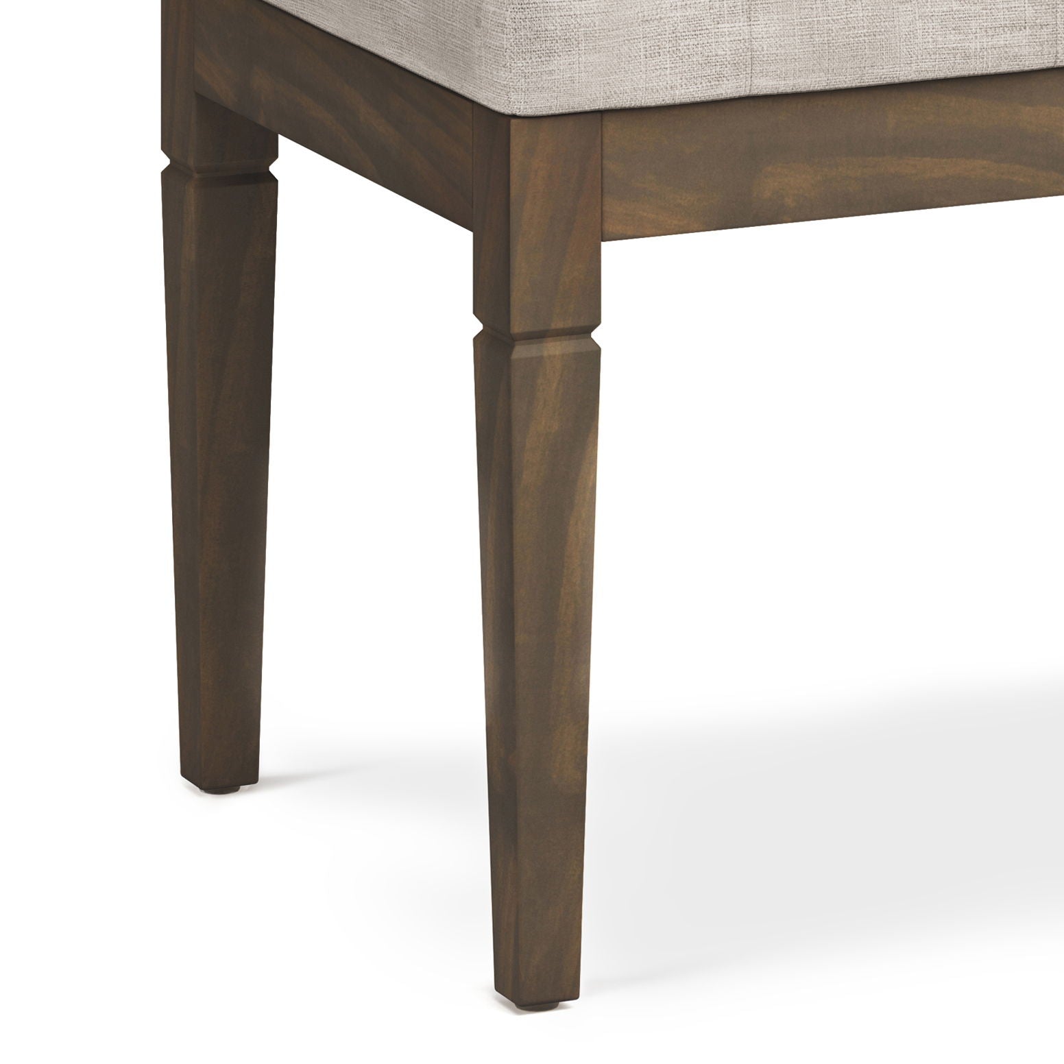 Close-up view of the corner of the Waverly - Upholstered Tufted Ottoman Bench, featuring tapered wooden legs and a light-colored upholstered seat cushion.