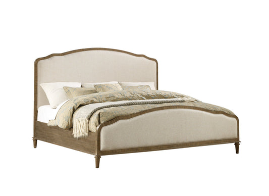The Ludin - Upholstered Bed features a wooden frame with an upholstered headboard and footboard, styled in white and light beige bedding with patterned pillows and a neatly folded blanket.