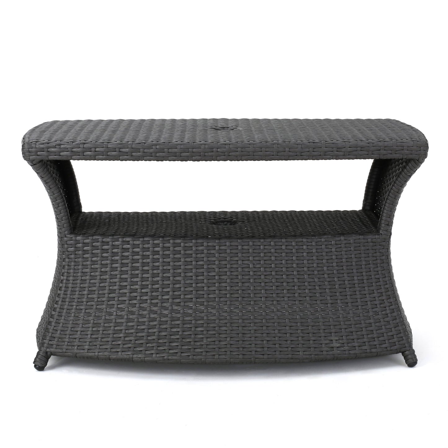 The Berkeley - Chaise Lounge Side Table features a rectangular, dark brown woven wicker design with curved sides, an open shelf under the tabletop, and stands on four legs.