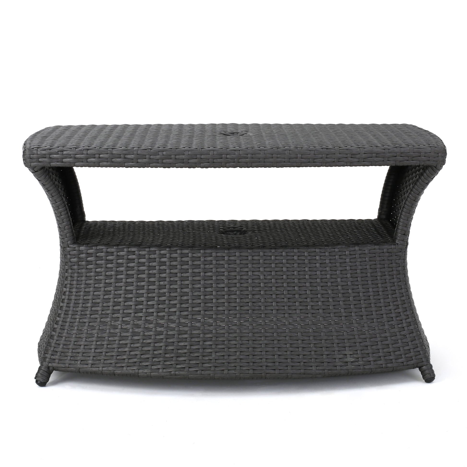 The Berkeley - Chaise Lounge Side Table features a rectangular, dark brown woven wicker design with curved sides, an open shelf under the tabletop, and stands on four legs.