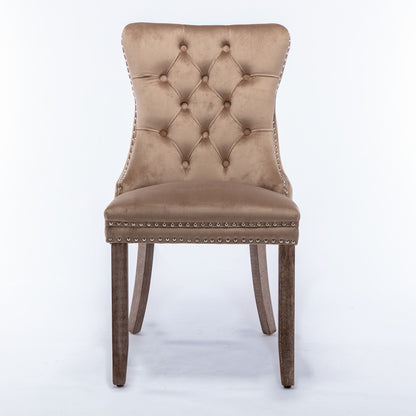 The Nikki set includes two modern, high-end dining chairs with tan velvet upholstery, diamond tufted backs, nailhead trim, and solid wood legs—contemporary style shown on a white background.