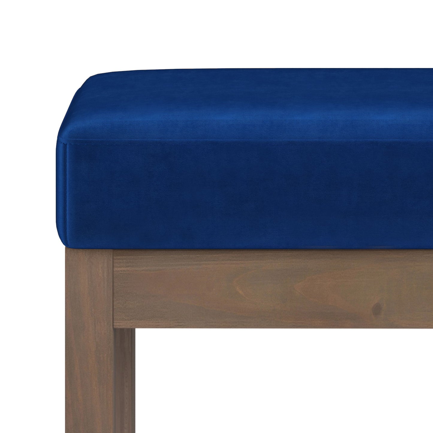 Close-up of the Milltown Upholstered Ottoman Bench featuring a blue velvet cushion and wooden frame, set against a white background.