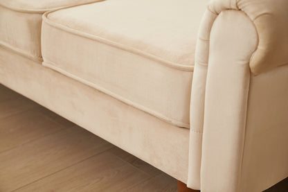 Close-up of the Graceful Design Plush Comfort Sofa, featuring beige upholstery, plush seat cushions, rounded armrest, and wooden legs on a wooden floor.