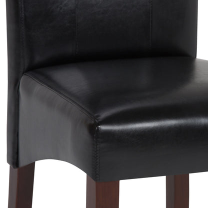 Close-up of the Cosmopolitan - Deluxe Tufted Parson Upholstered Chair, showcasing its black leather seat and backrest with dark wooden legs. The visible stitching and smooth leather texture highlight its elegant design. Comes as a set of 2.