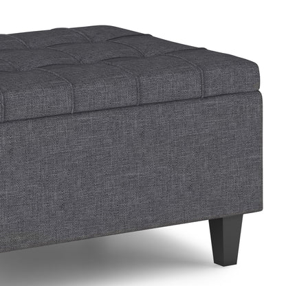 A close-up of the Harrison Upholstered Coffee Table Storage Ottoman in dark gray, featuring tufted detailing and black wooden legs, shown on a white background.