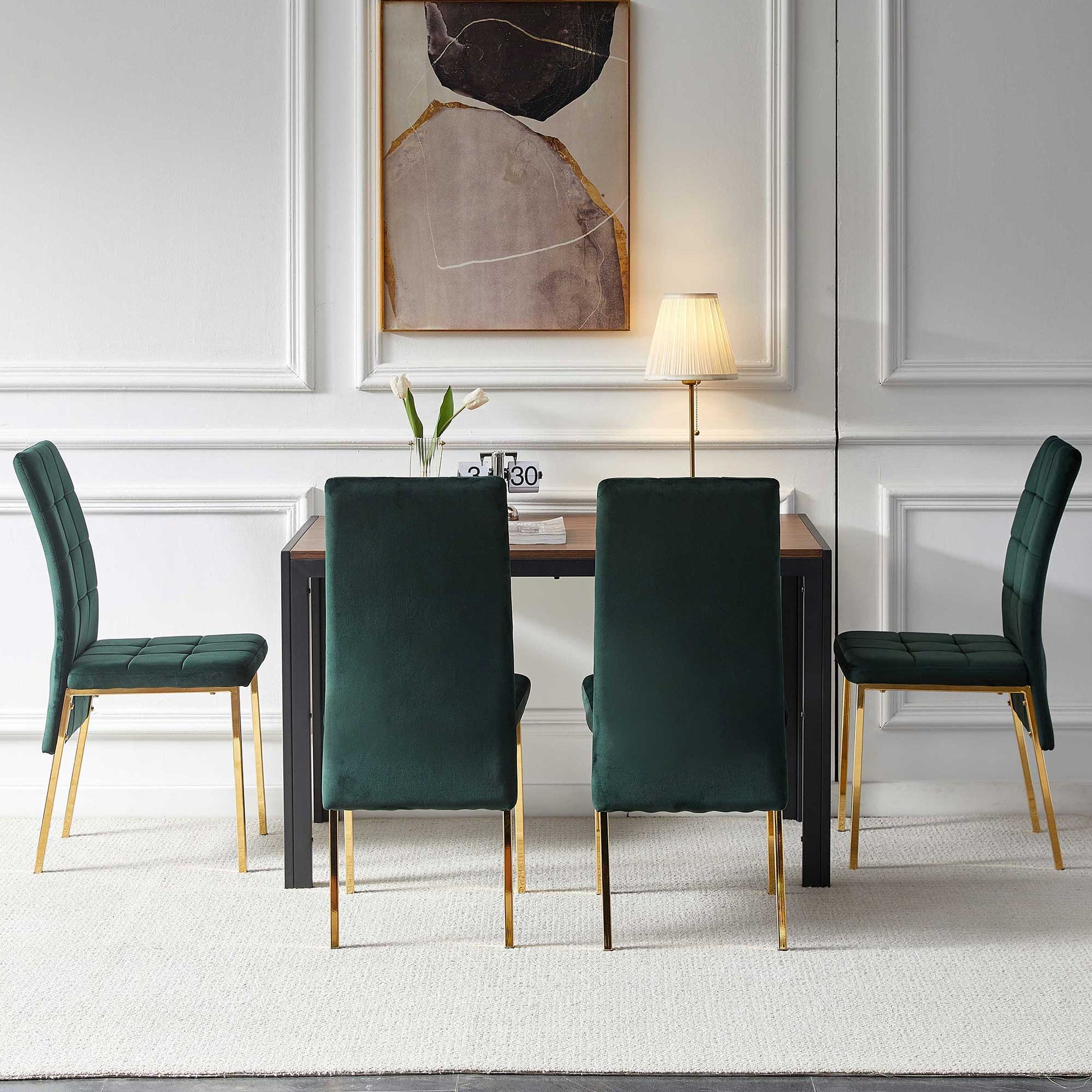 The 5-piece dining set features velvet high back chairs with golden legs surrounding a creative design dining table, complemented by a lamp, a vase with flowers, and decorative books beneath a modern abstract painting on the white wall.