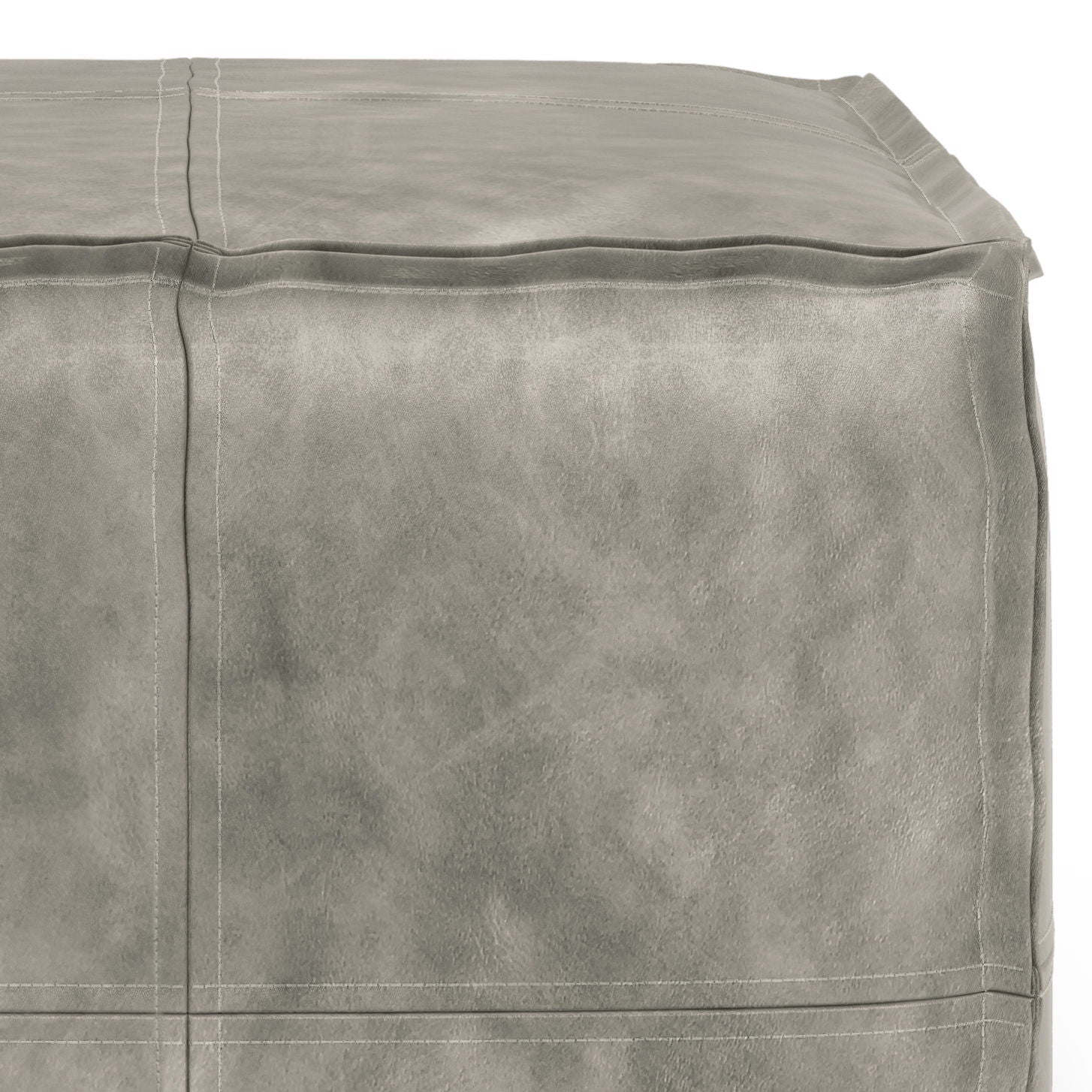 Close-up view of the Brody - Versatile Square Pouf, a light gray leather ottoman featuring visible seams and surface stitching.