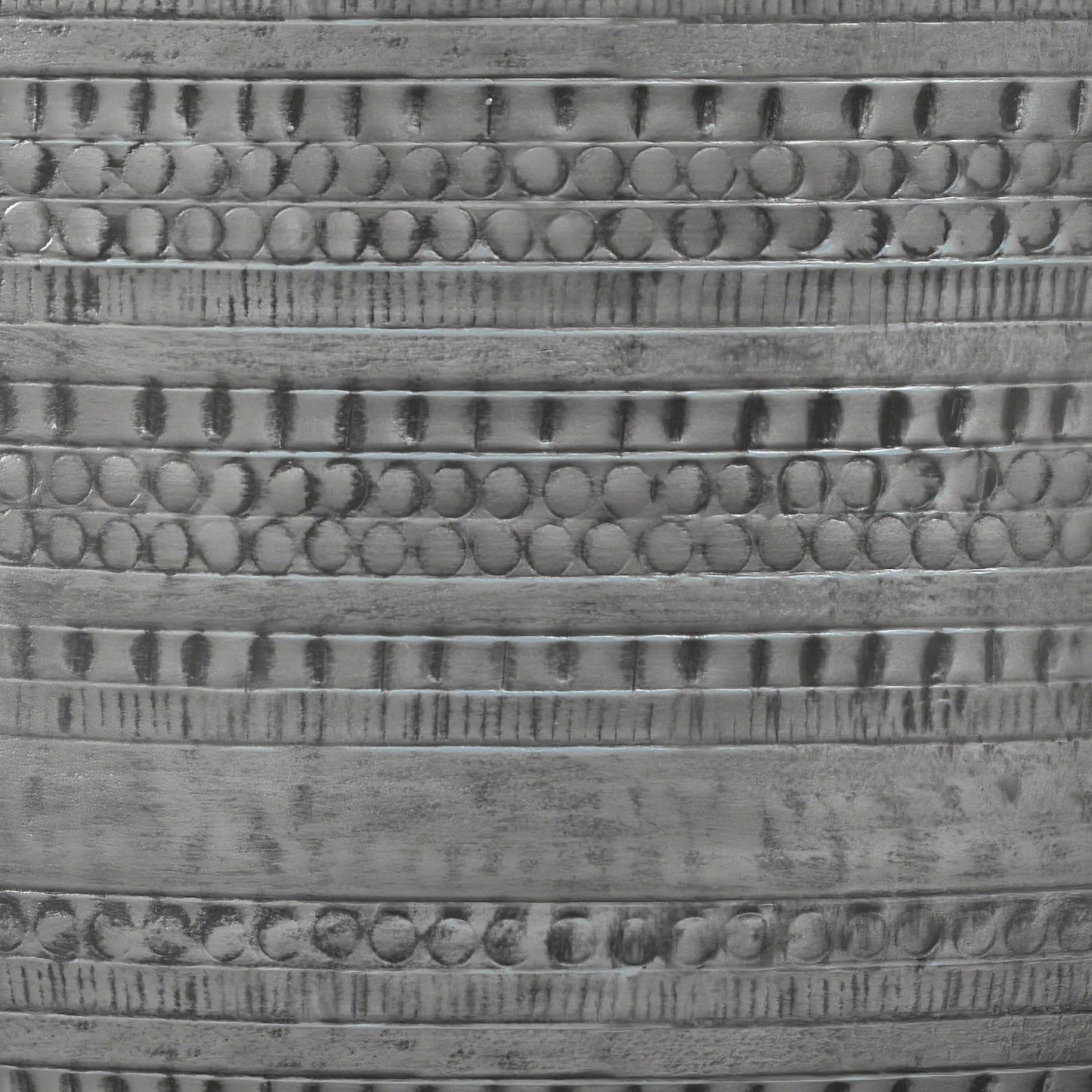 Close-up of the Johnsen Handcrafted Metal Coffee Table's metallic surface, featuring horizontal bands with repeating circular and linear engraved patterns for a textured, reflective finish.
