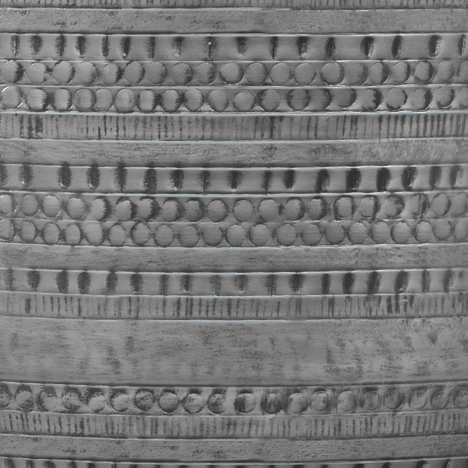 Close-up of the Johnsen Handcrafted Metal Coffee Table's metallic surface, featuring horizontal bands with repeating circular and linear engraved patterns for a textured, reflective finish.