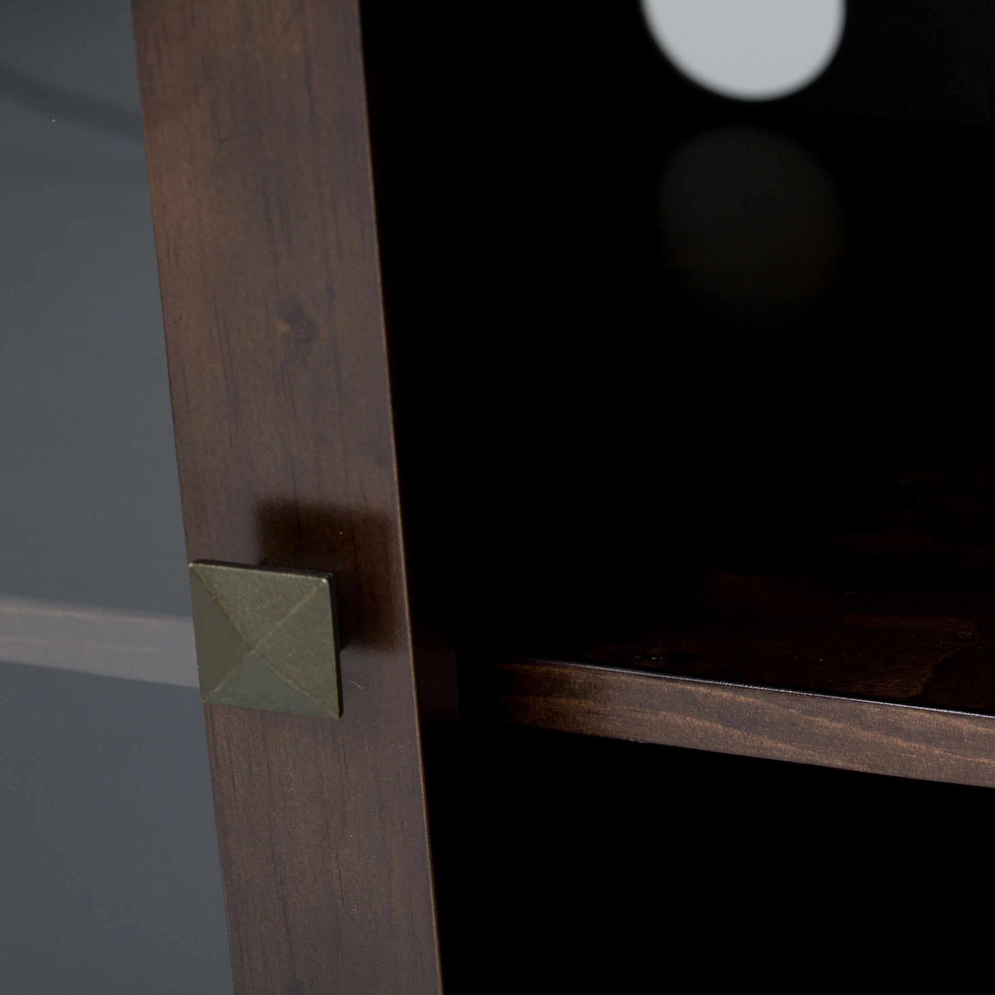 Close-up of the Cosmopolitan - Handcrafted TV Media Stand in dark wood, featuring a square metallic knob, an interior shelf, and a circular cable management cutout on the back panel.