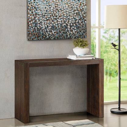 A modern entryway includes the Modern Design Console Table with a small plant and stacked books, a floor lamp, a patterned rug, and mosaic-style artwork displayed above the table.
