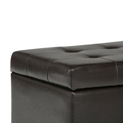 A close-up of the Cosmopolitan - Upholstered Storage Ottoman in dark brown leather, featuring tufted detailing, visible stitching, and a cushioned top.