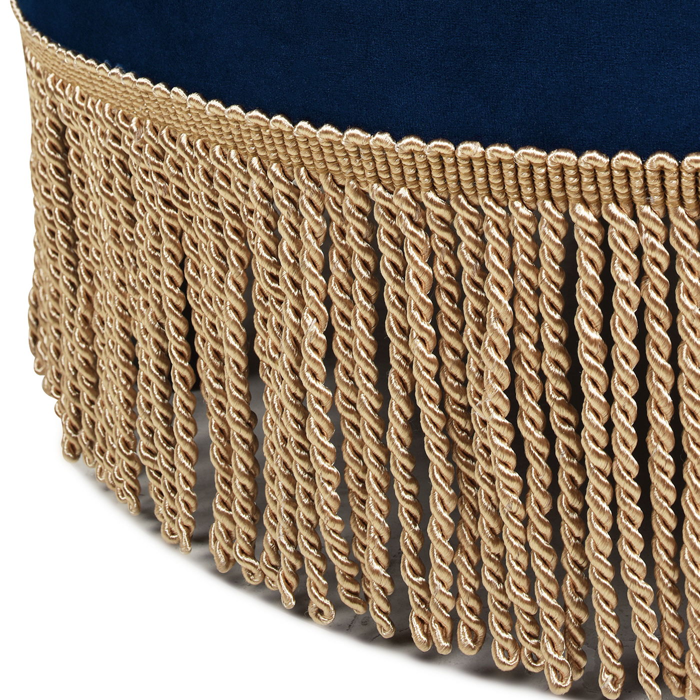 Close-up of decorative gold-colored twisted fringe attached to the edge of the Yolanda - Round Upholstered Accent Ottoman in dark blue fabric.