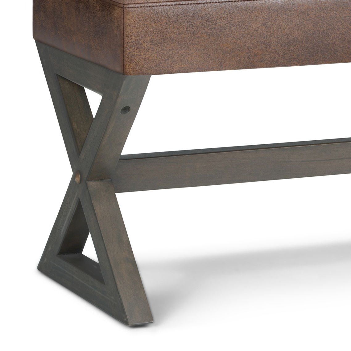 Close-up of the Salinger - Large Upholstered Ottoman Bench, highlighting its brown leather seat and dark wooden legs with a unique X-shaped design and horizontal support bar.