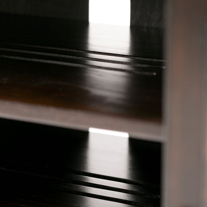 Close-up of Amherst - TV Media Stand, Handcrafted: dark wooden shelves with grooves, backlit to create reflections on the surfaces.