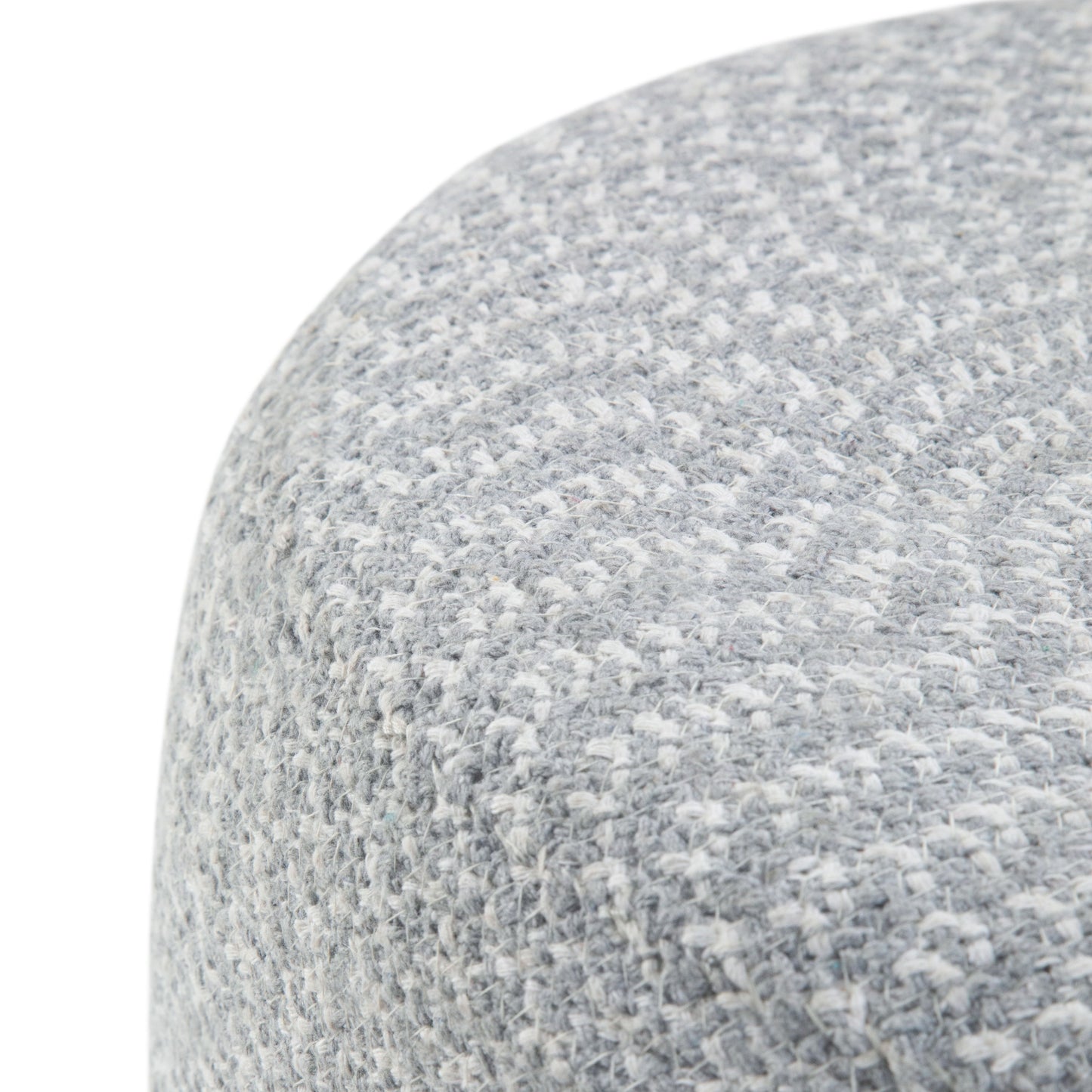 Close-up of the Bayley - Versatile Round Braided Pouf, showing its light gray textured fabric with a subtle woven pattern and curved edge, highlighting the soft upholstery material.