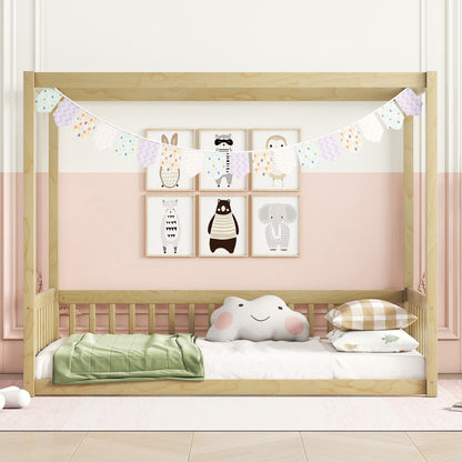 A Canopy Frame Floor Bed With Fence, Guardrails is styled with a pastel garland, animal-themed wall art, a cloud pillow, and neatly folded bedding against a two-tone pink and white wall in a cozy nursery.