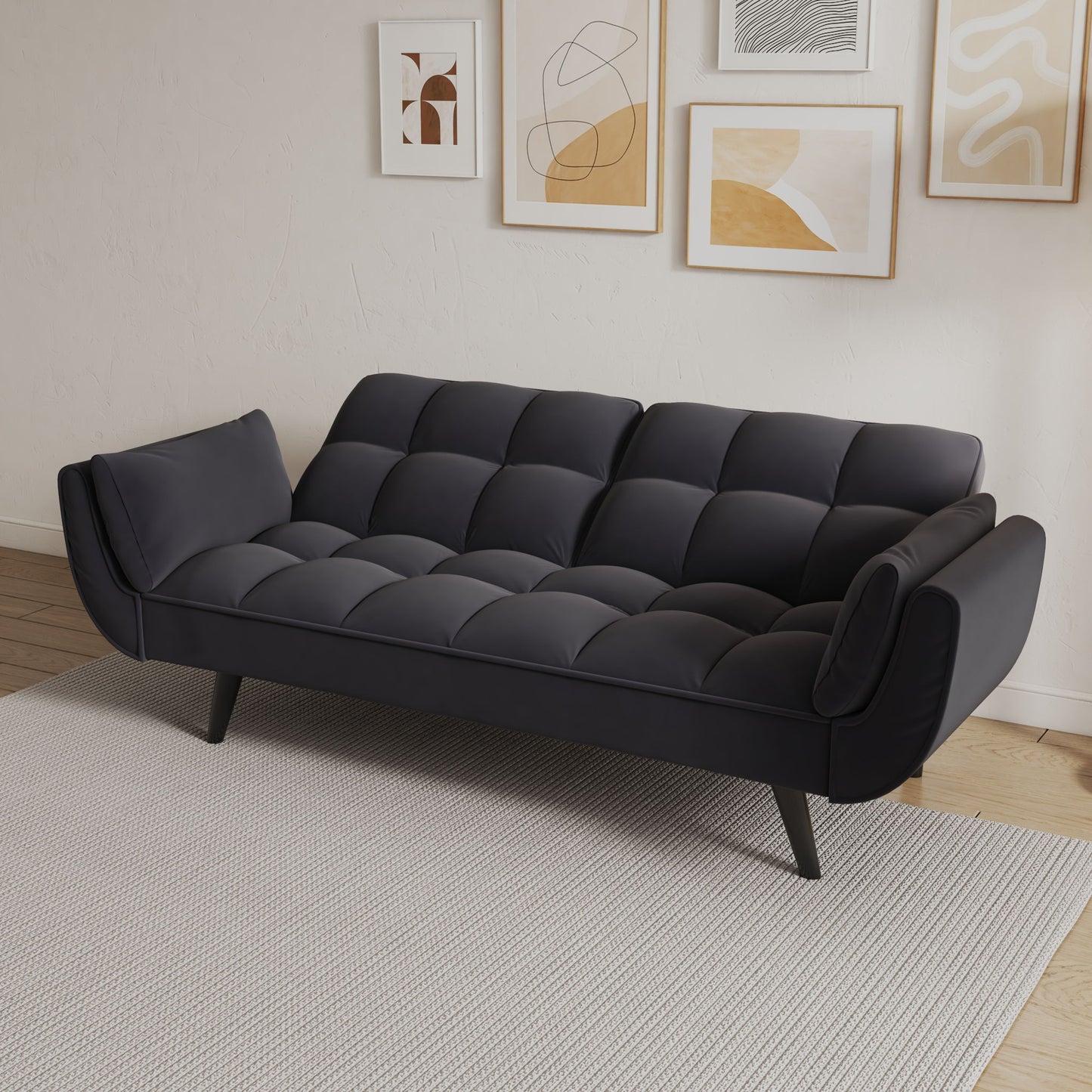 A Sofa Soft with two armrests and throw pillows sits on a light gray rug. Abstract framed art hangs on the white wall above, and a wood floor completes the modern small space apartment or bedroom look.