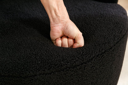 A hand presses into the cushion of the Teddy Fabric Swivel Accent Armchair Barrel Chair With Powder Coating Metal Ring, testing its softness and leaving a visible indentation.