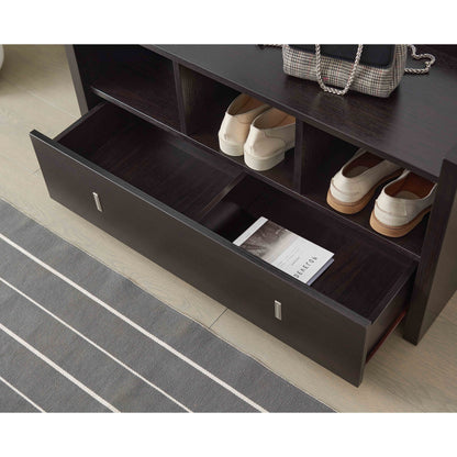 A Shoe Entry Bench With Three Shelves and a divided drawer holds a book, while the shelves above store two pairs of shoes. A striped rug and a small handbag are partially visible nearby.