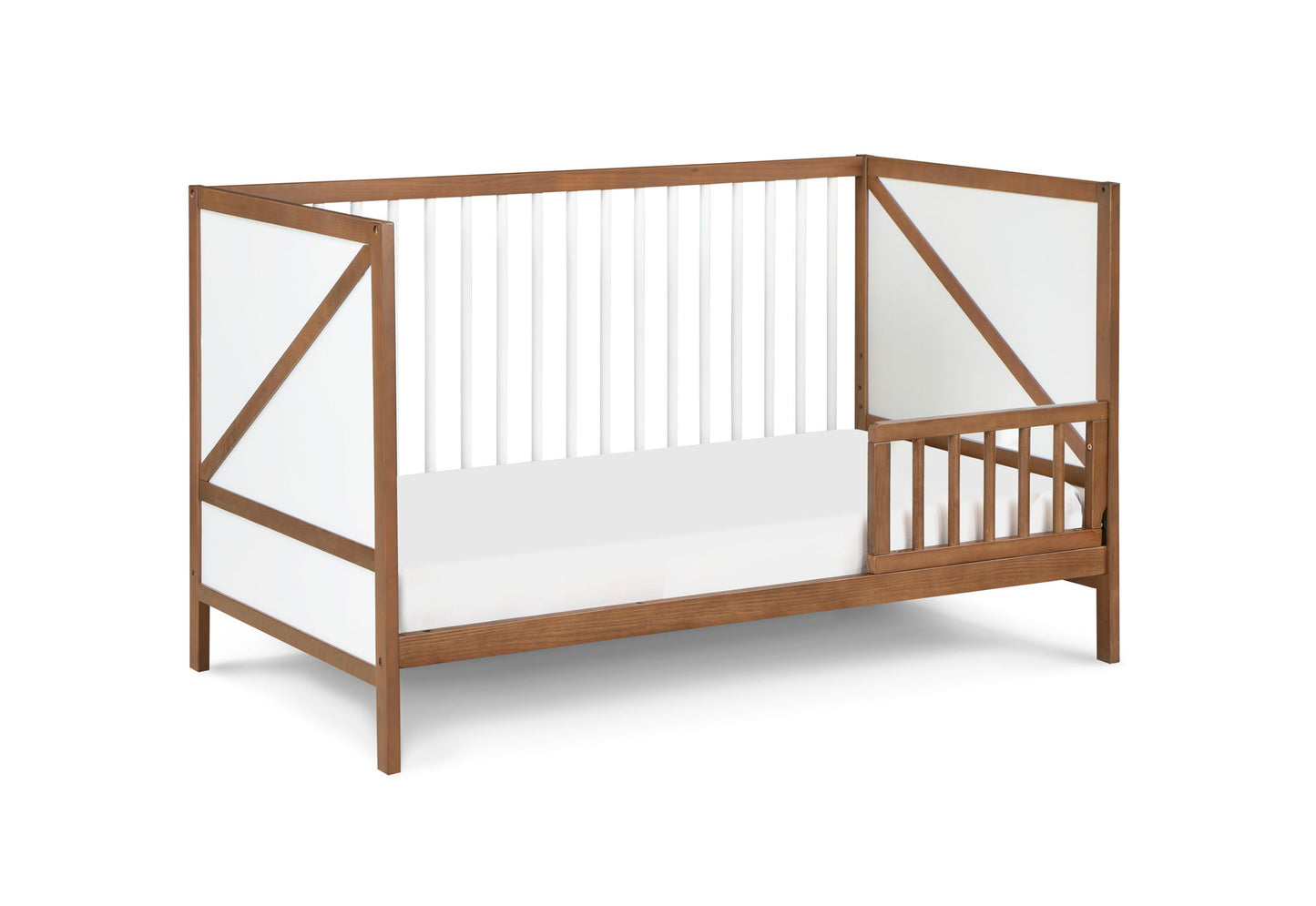 The Pixie Zen 3-in-1 Crib in Walnut is a modern wooden toddler bed with white panels and slatted sides and end, plus an open section with small vertical bars for easy access.