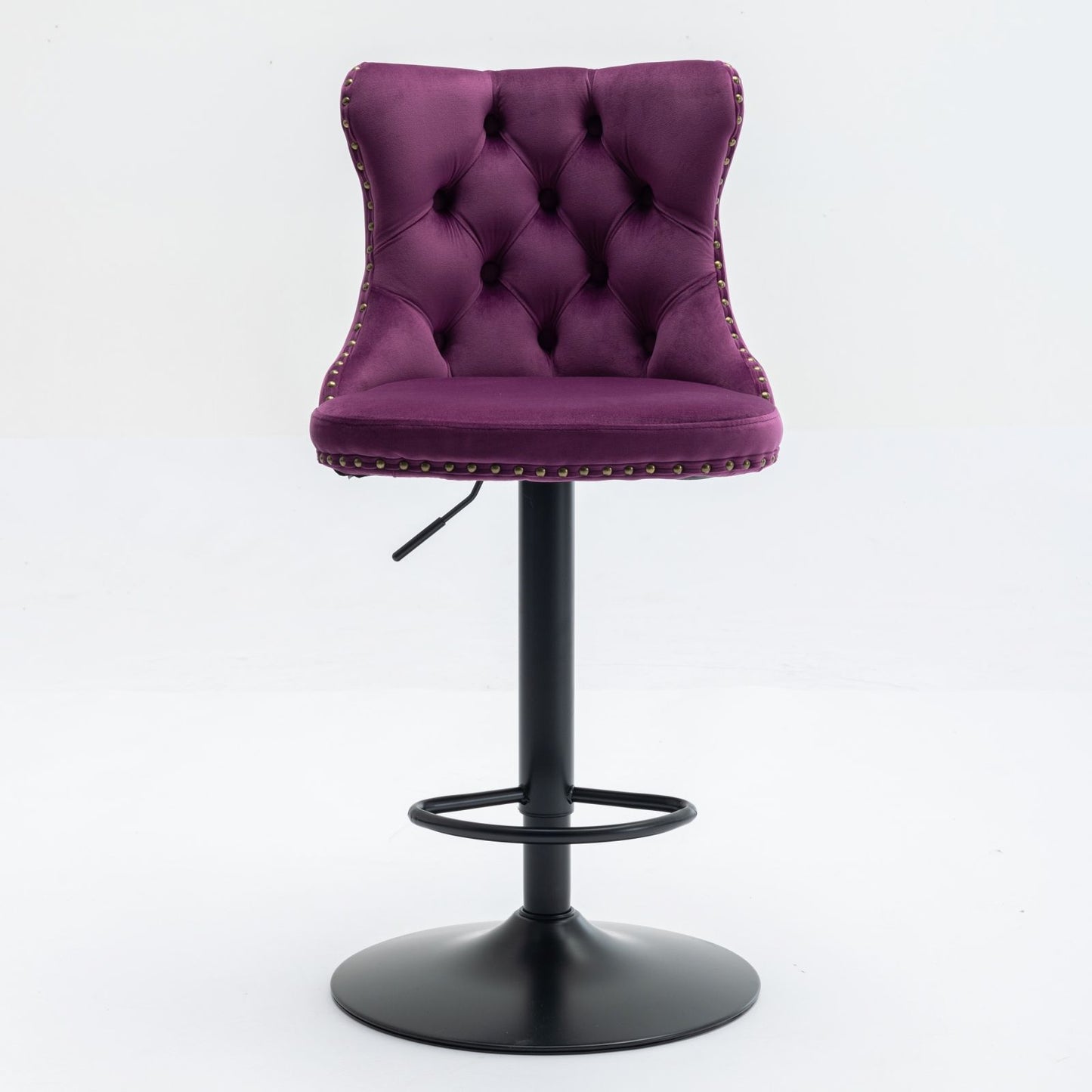 A set of 2 modern purple swivel velvet barstools with tufted backs, silver nailhead trim, and a black adjustable pedestal base with circular footrest, perfect for home pub or kitchen island. Set against a white background.