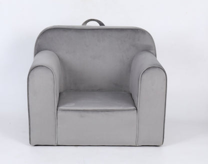 The Durable Design Kids Club Sofa is a small, light gray upholstered armchair with rounded arms, a slightly curved backrest, and a fabric handle at the top for easy carrying. It is shown against a plain white background.