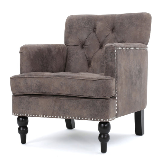 The Vitality Club Chair features a plush gray design with button tufted diamond stitching, studded trim, and elegant black turned legs, displayed against a white background.