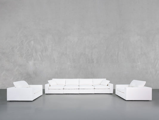 A minimalist living room showcases the 4-1-1 Sofa & Armchair Set, featuring a modern white sofa and two matching armchairs with clean lines, set against a smooth grey wall and floor.