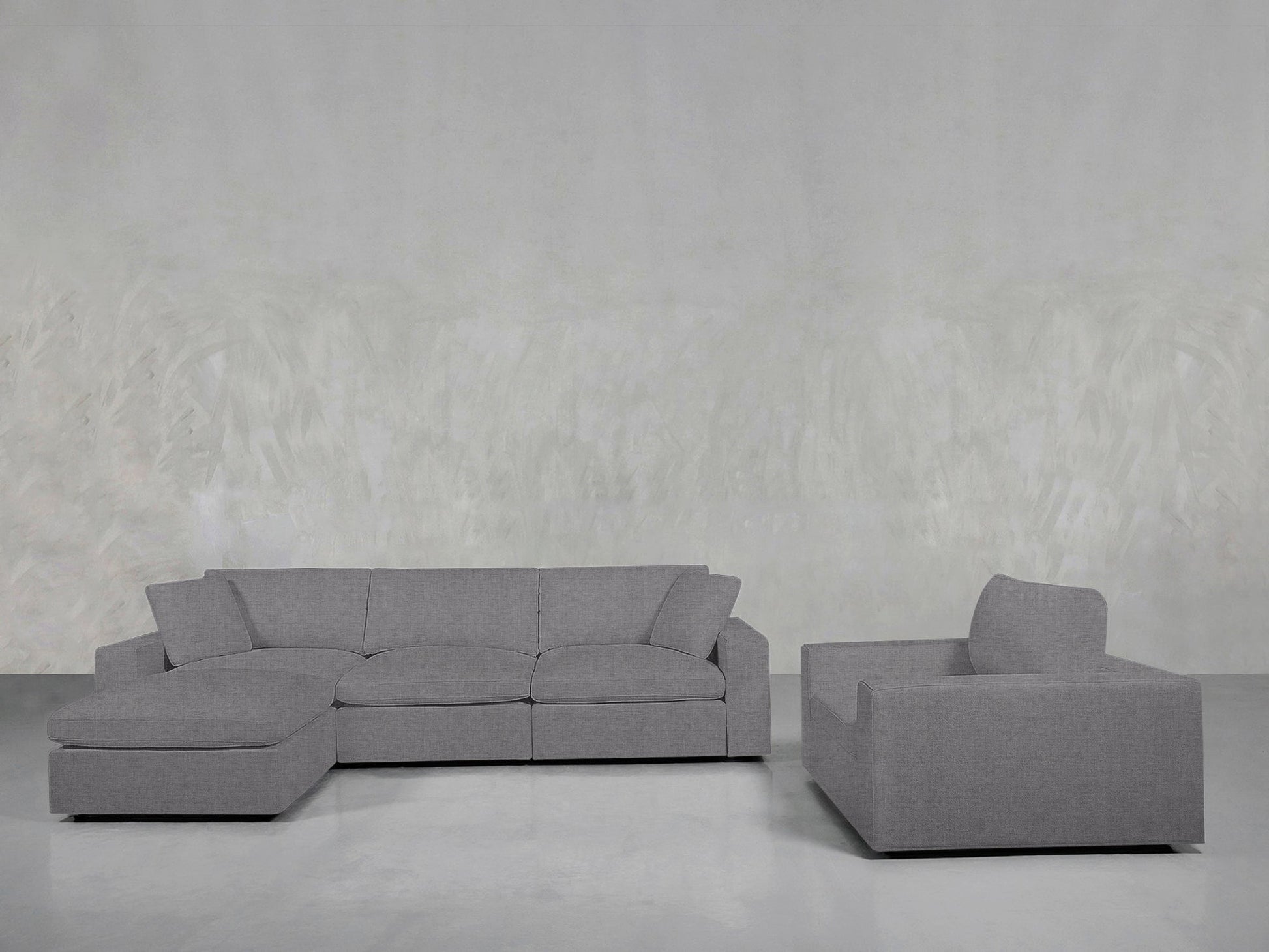 The 4-1 Sectional & Armchair Set features a light gray sectional sofa with a left-facing chaise and a matching armchair, arranged against light gray textured walls and flooring for a modern living room look.