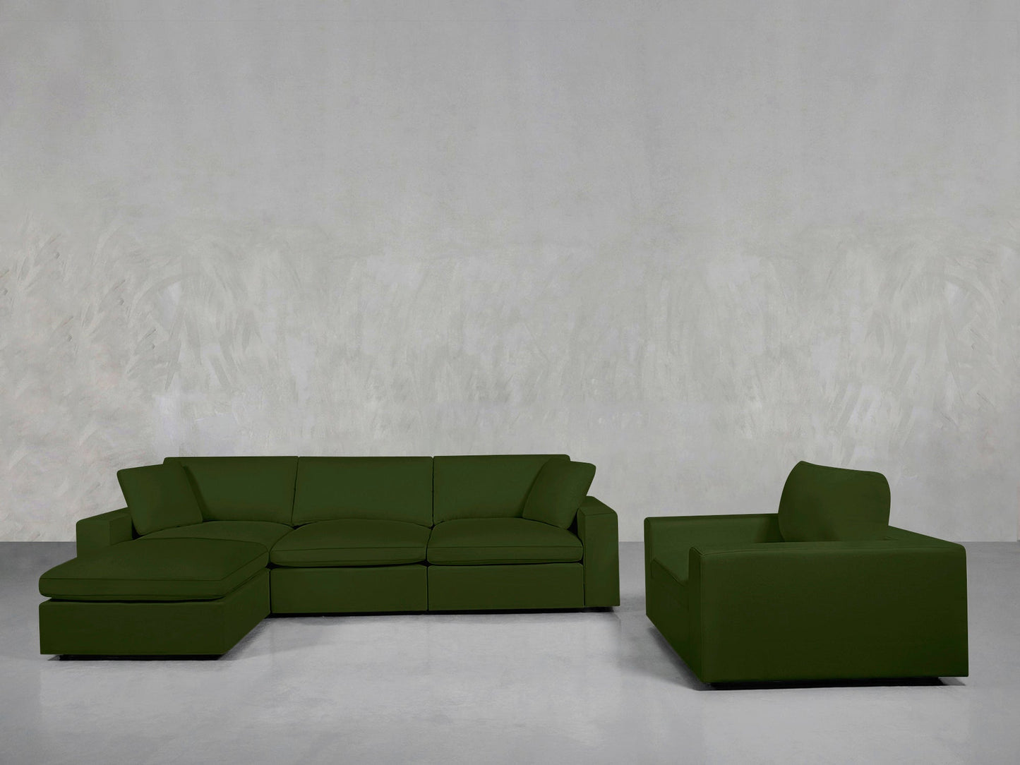 A modern living room featuring the 4-1 Sectional & Armchair Set in green, arranged on a gray floor with a light gray textured wall backdrop.