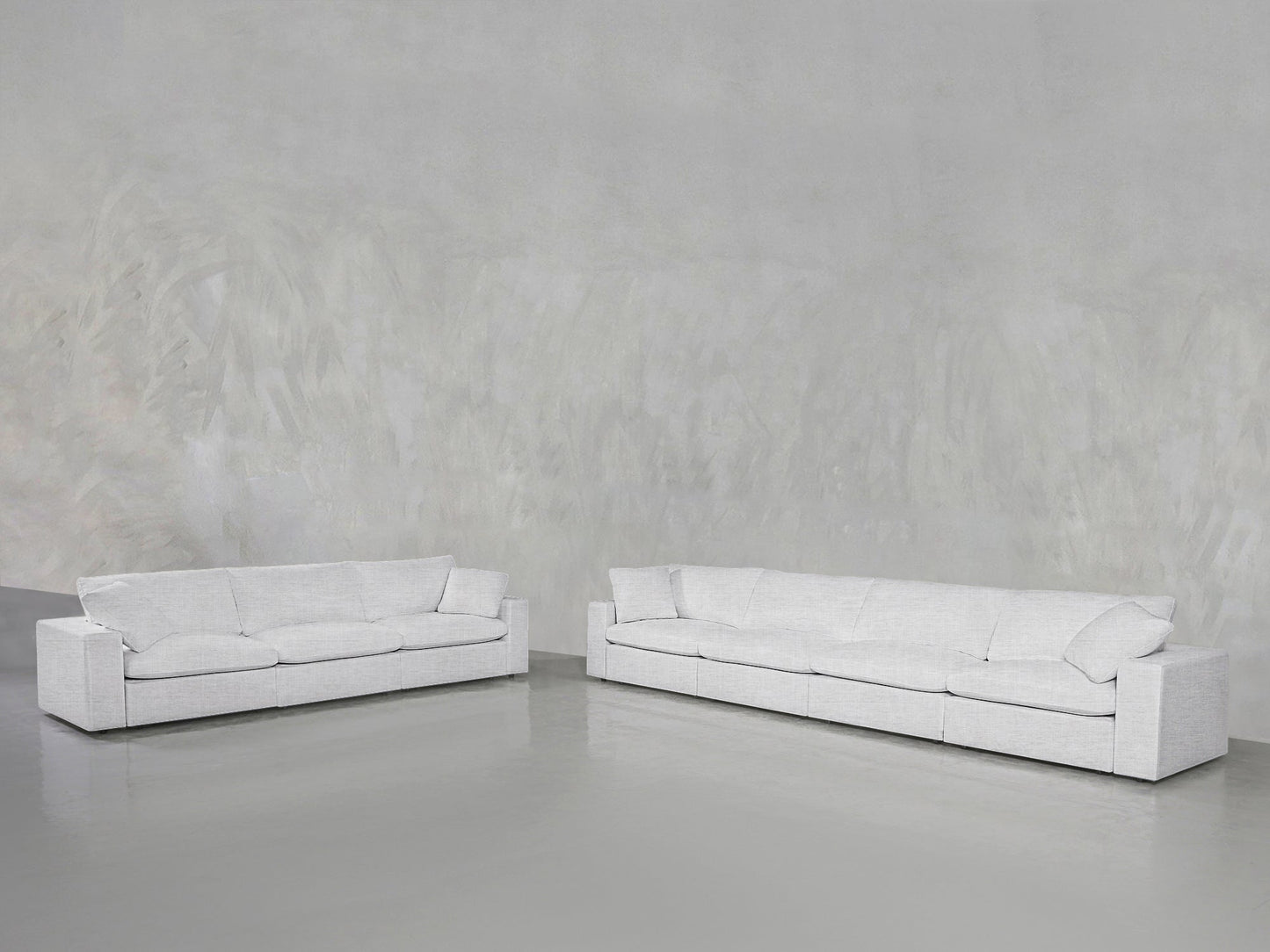 The 4-3 Sofa Set features two modern, minimalist white sofas with clean lines, placed on a glossy gray floor against a textured light gray wall in a spacious, empty room.