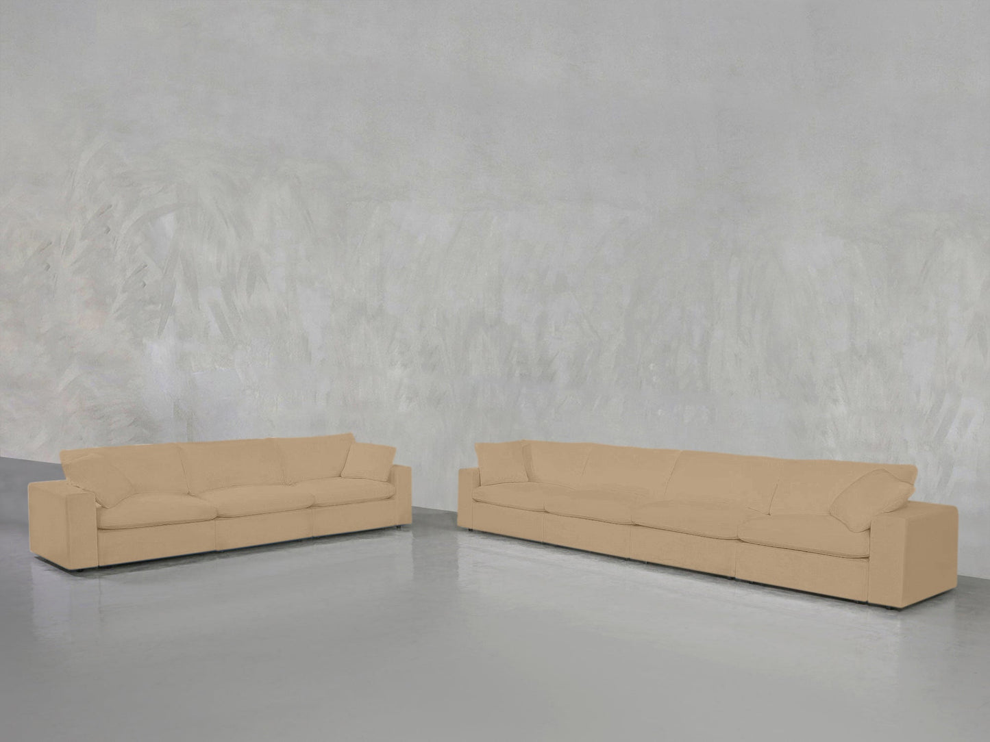 The 4-3 Sofa Set, featuring two beige sofas with clean, modern lines, is arranged at an angle in a minimalist room with a gray textured wall and a shiny light gray floor.