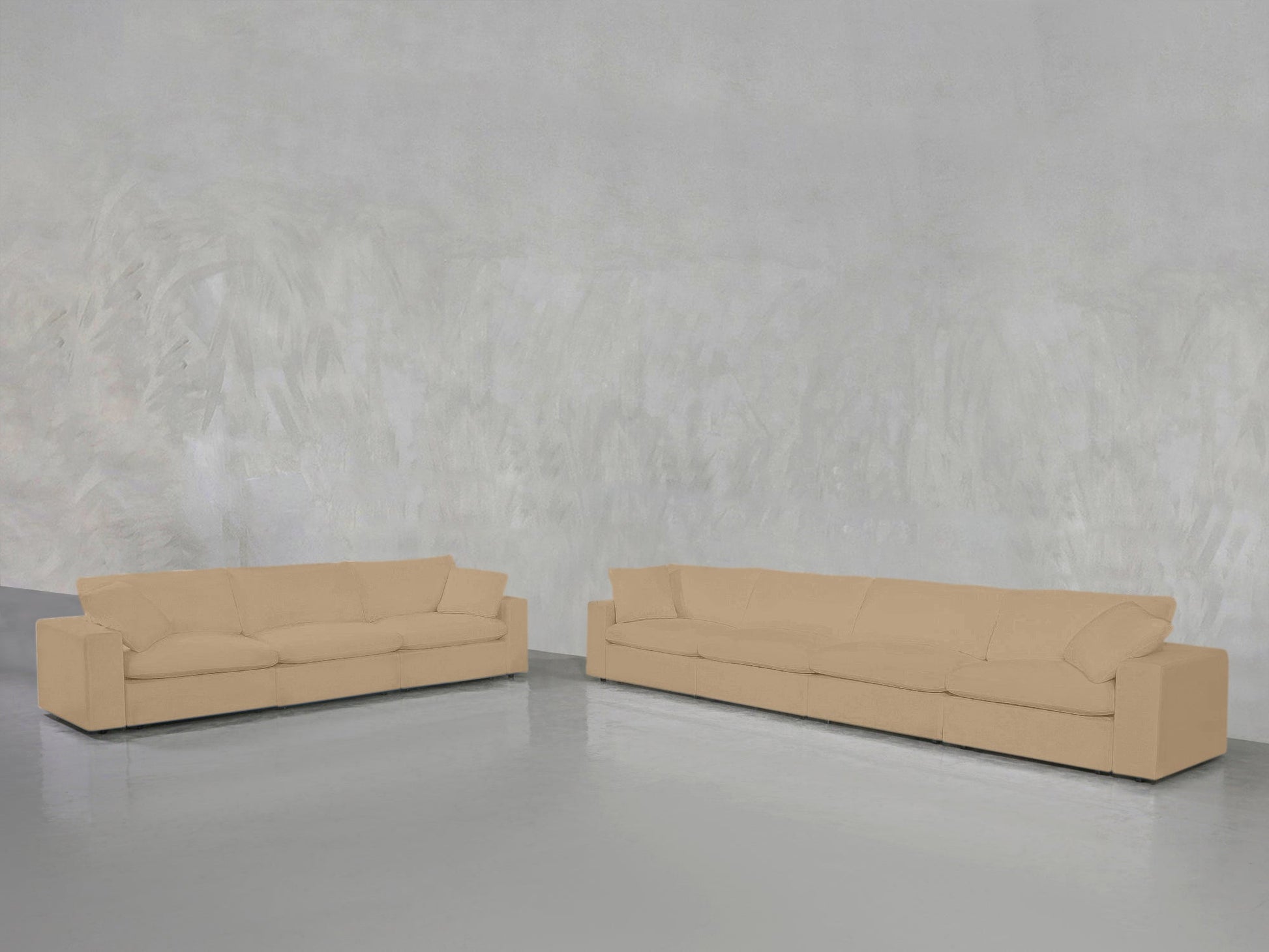 The 4-3 Sofa Set, featuring two beige sofas with clean, modern lines, is arranged at an angle in a minimalist room with a gray textured wall and a shiny light gray floor.