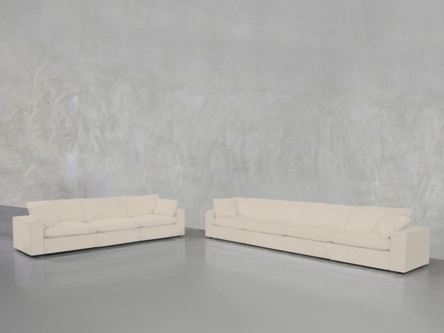 The 4-3 Sofa Set, featuring two modern cream sofas with square arms, is arranged against a light gray textured wall and glossy gray floor in a minimalist open space.