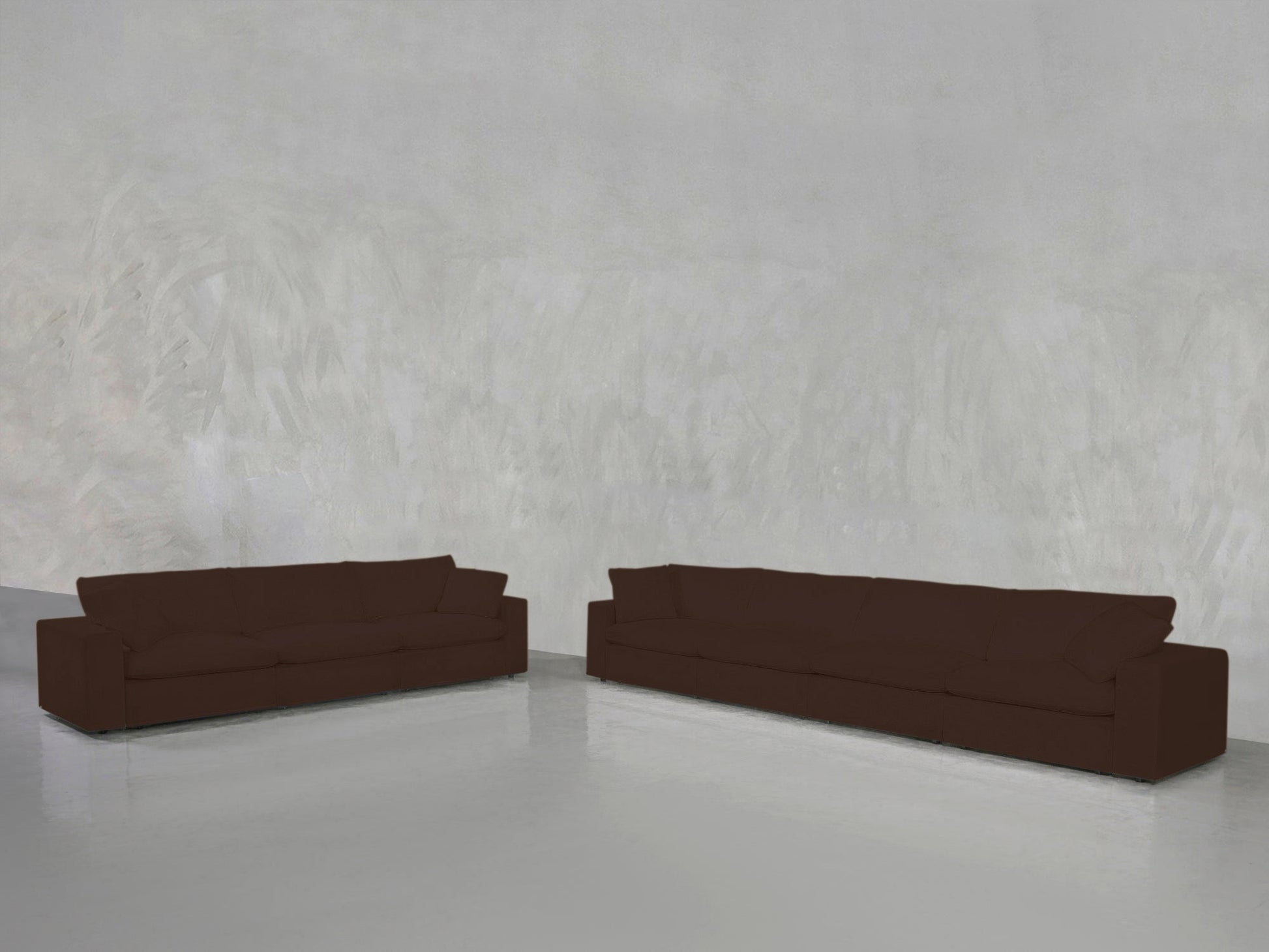 The 4-3 Sofa Set, featuring two modern brown sofas, is arranged in a minimalist room with light gray textured walls, a shiny reflective floor, and an open, sparsely decorated space.