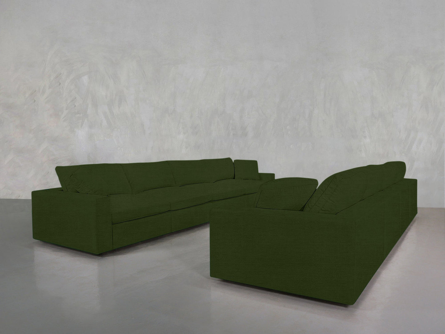 The 4-4 Sofa Set features two dark green, modern, boxy sofas arranged in an L-shape in a minimalist room with textured light gray walls and a polished gray floor.