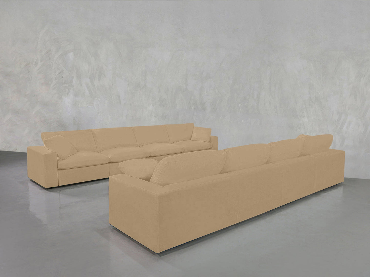 The 4-4 Sofa Set, featuring two beige, modern boxy sofas, is arranged in an L-shape on a shiny gray floor against a textured light gray wall.