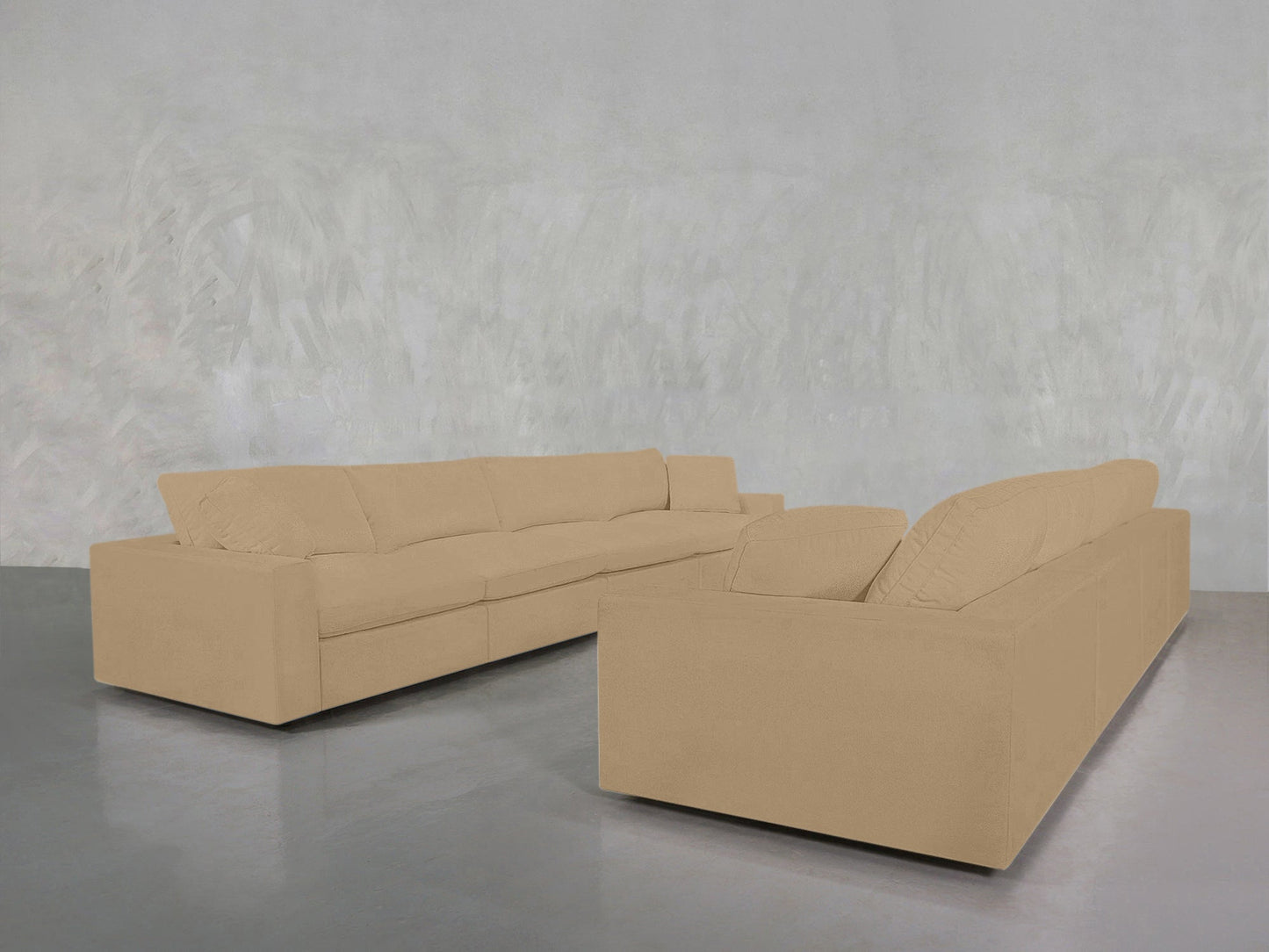 The 4-4 Sofa Set, a large beige sectional with clean modern lines, sits in a minimalist room featuring a light gray textured wall and a glossy gray floor.