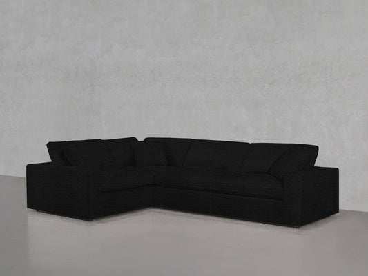 A 4-Seat Modular Corner Sectional is arranged against a light gray textured wall on a light gray floor, with matching cushions.