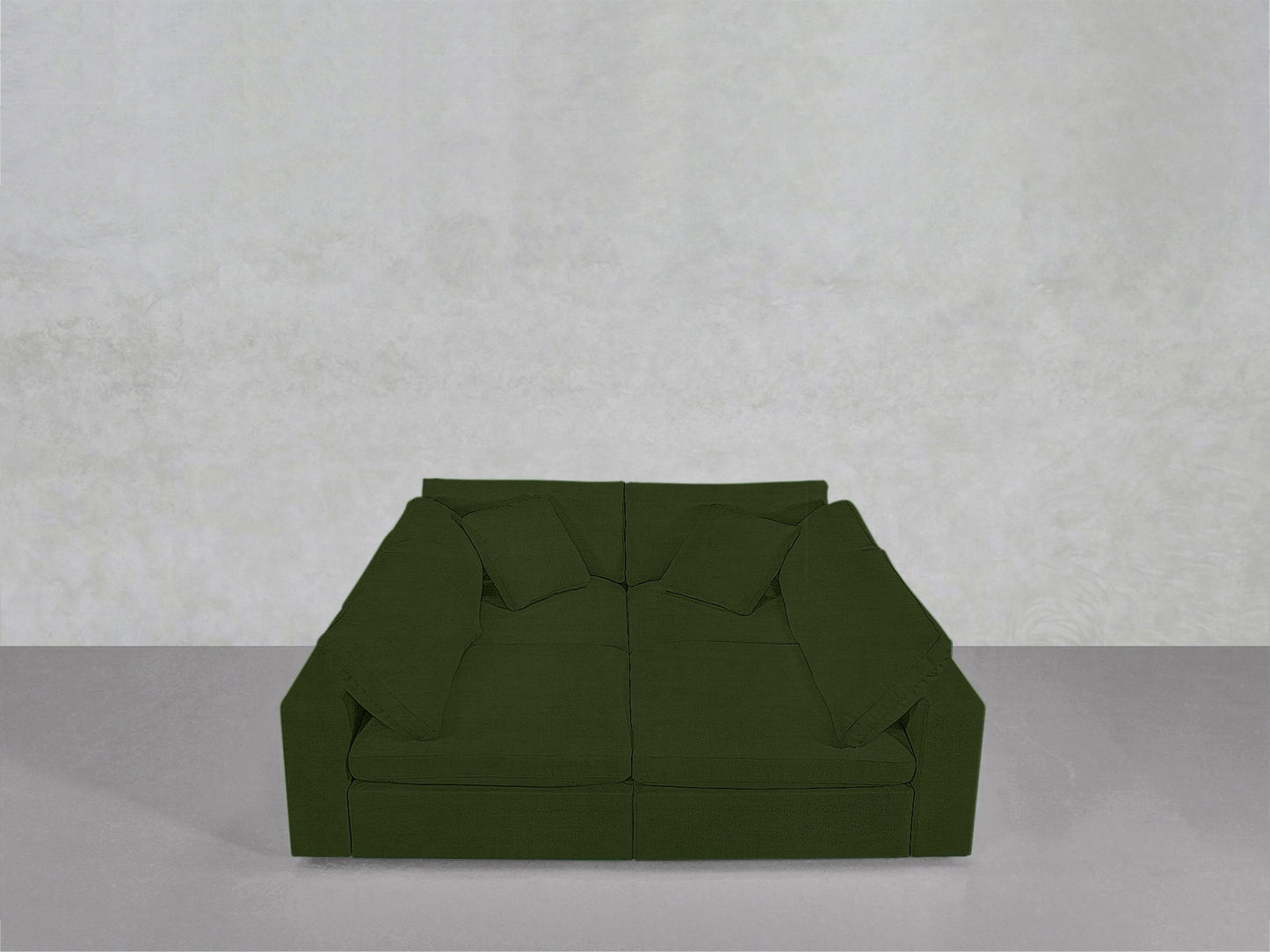 A modern dark green 4-Seat Modular Pit is placed against a plain light gray wall and sits on a clean, smooth gray floor with two square cushions.